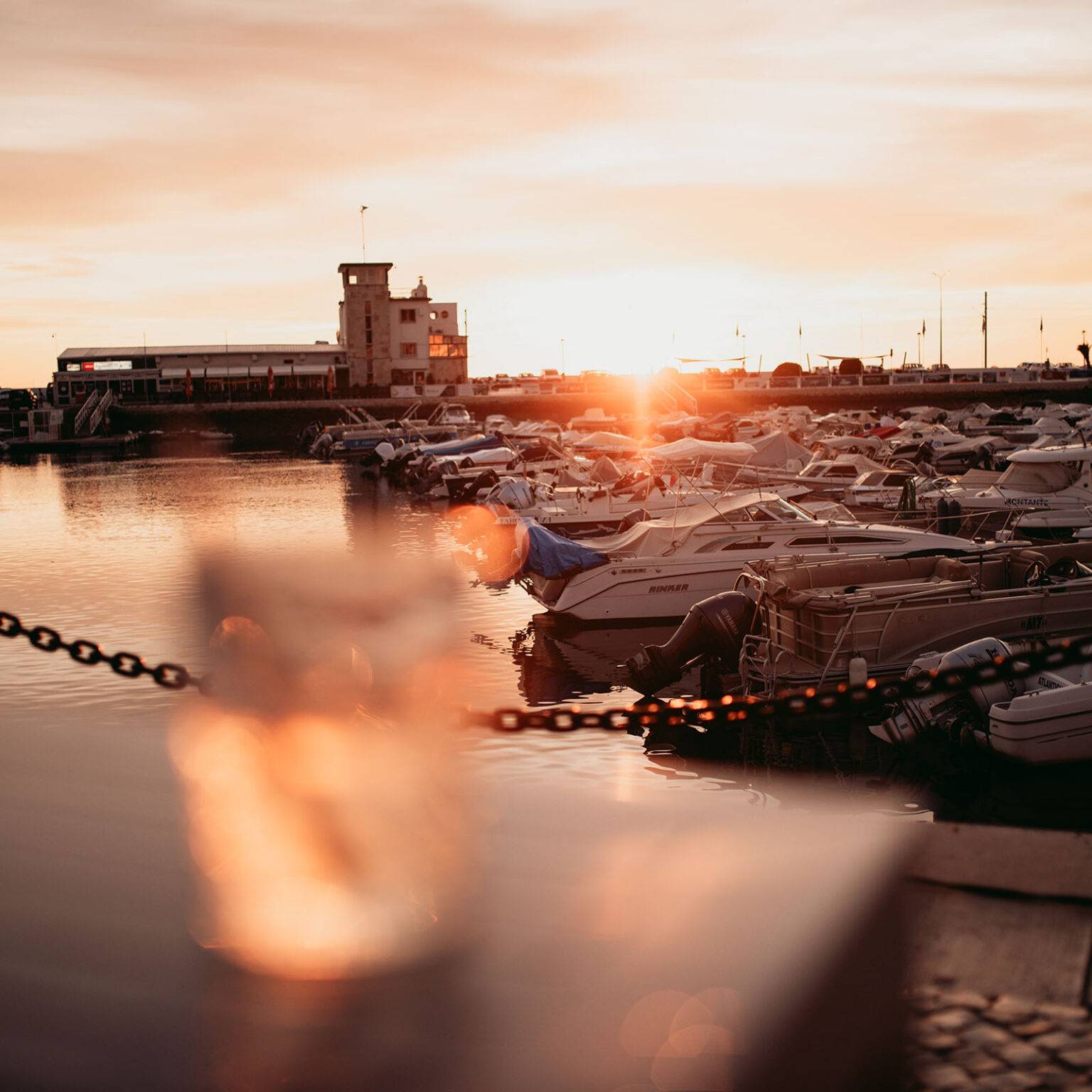 Ein Sonnenuntergang erhellt den Hafen Marina von Faro.