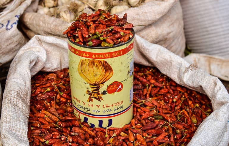 In einem großen weißen Sack werden kleine getrocknete Chillischoten auf einem Markt in Harar, Äthiopien zum Verkauf angeboten.