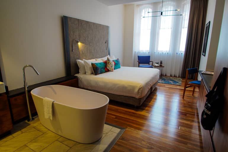 Die Zimmer des The Old Clare Hotels in Sydney, Australien verfügen über ausreichend Platz, Holzboden und freistehender Badewanne.
