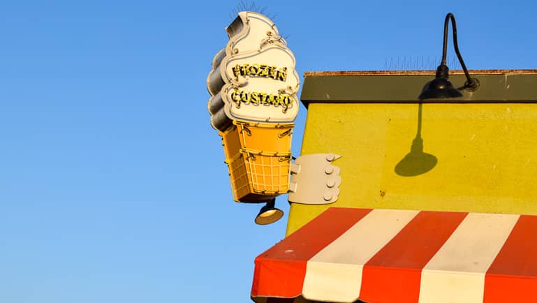 In Santa Monica, Los Angeles wurde auf einem gelben Dach einer Eisdiele ein Eis als Reklameschild angebracht, die typische Markise dazu ist rot-weiß gestreift.