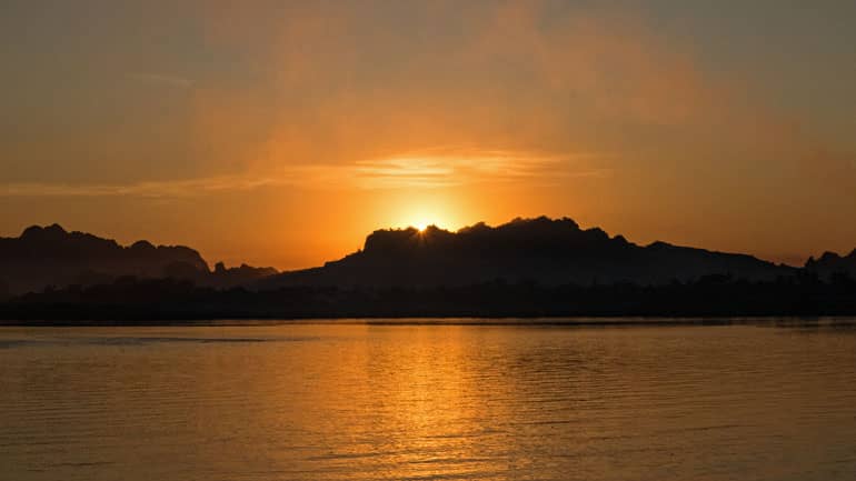 Sonnenuntergang hinter den Bergen am Kan Thar Yar See.