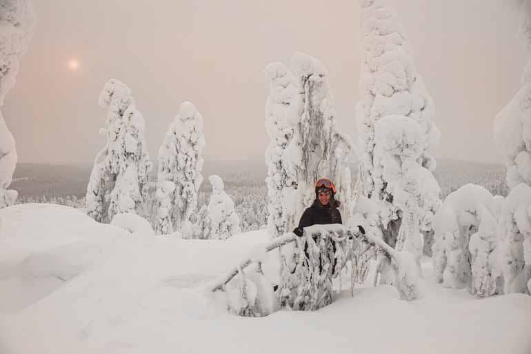 Eine Frau steht in einer Schneelandschaft in Finnisch Lappland.