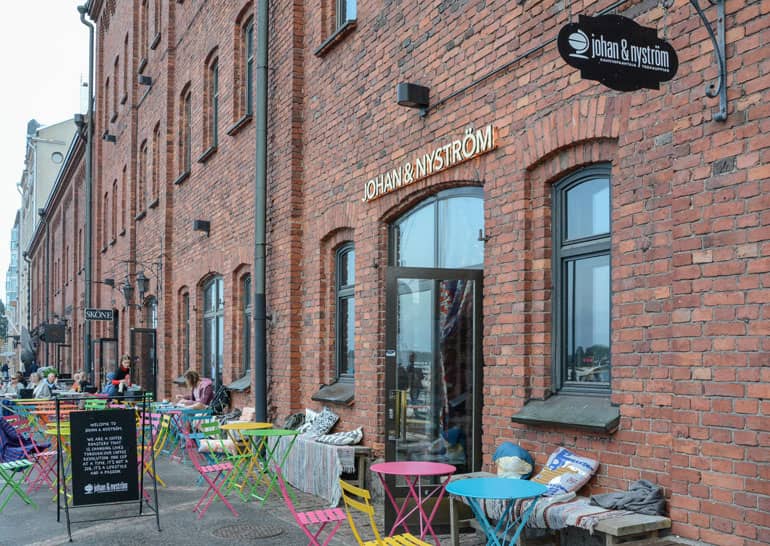 Helsinki: Restaurant mit Backsteinfassade und bunten Stühlen von außen.