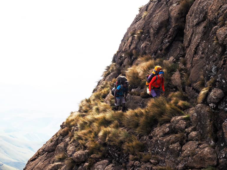 Südafrika Drakensberge: Zwei Wanderer auf einem Wanderweg des Roland´s Cave.