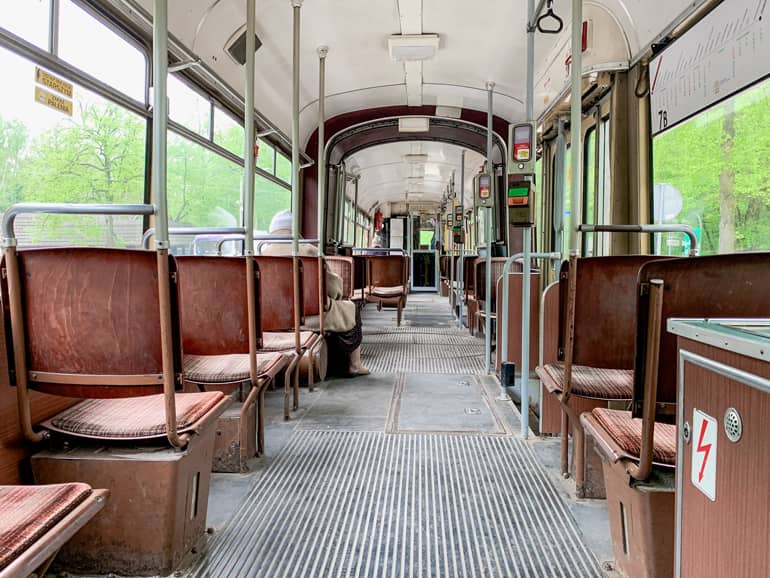 Eine Tram von innen mit roten Sitzen.