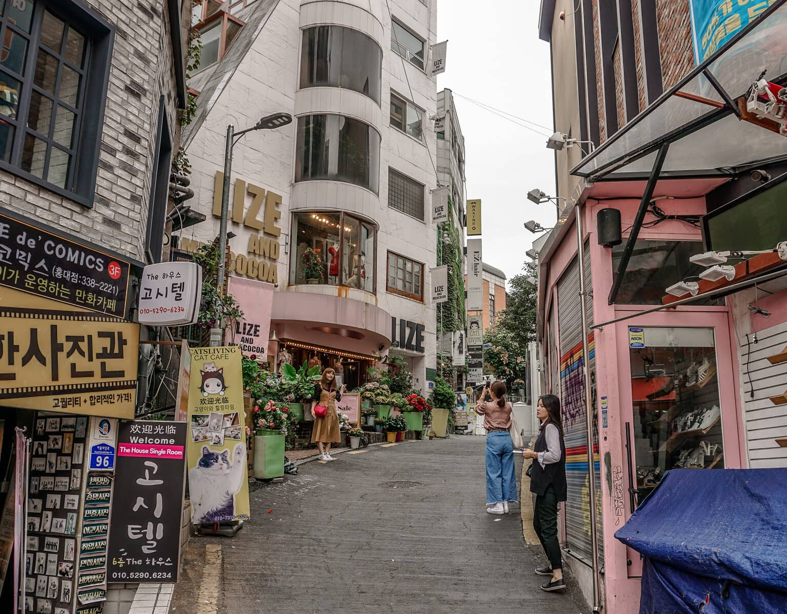 Sehenswüdigkeiten: Eine hippe Gasse in der Innenstadt von Seoul, eine Frau lässt sich fotografieren.