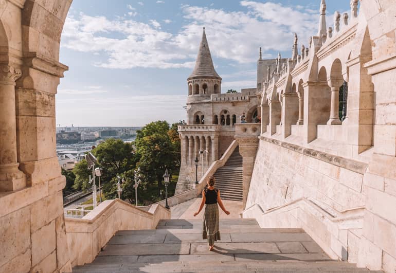 Budapest Städtetrip: Eine Frau die eine Treppe hinunter geht mit einem Gebäude im Hintergrund.