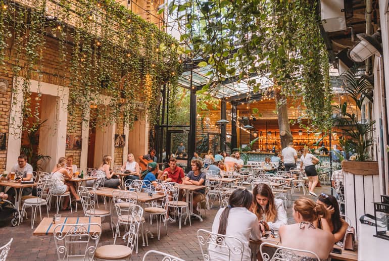 Budapest Städtetrip: Innenhof eines Restaurant mit Pflanzen die von der Decke hängen.