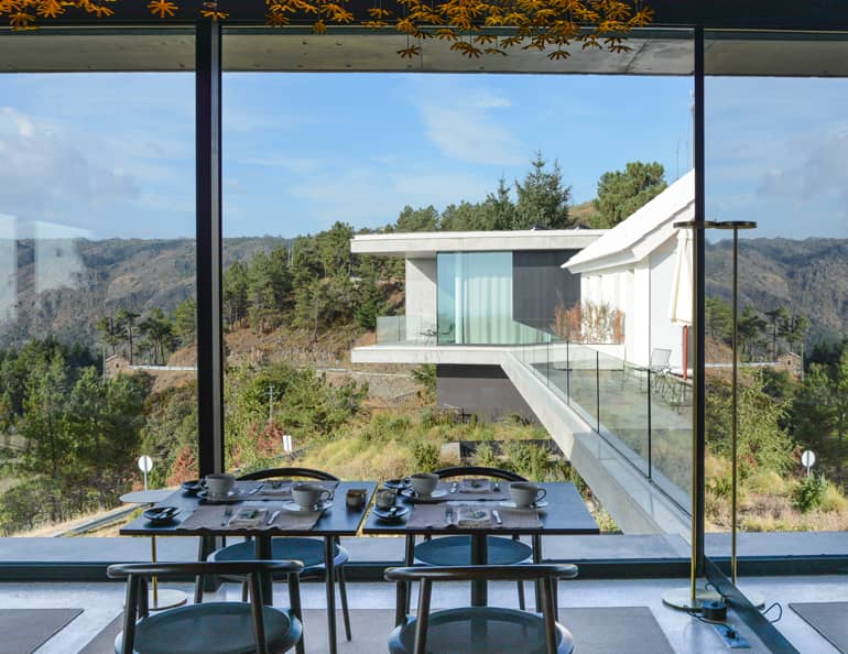 Ein modernes Haus mit einem großen Essbereich und großen Glasfenstern.