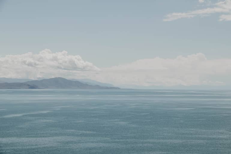 Das Meer mit Bergen im Hintergrund.