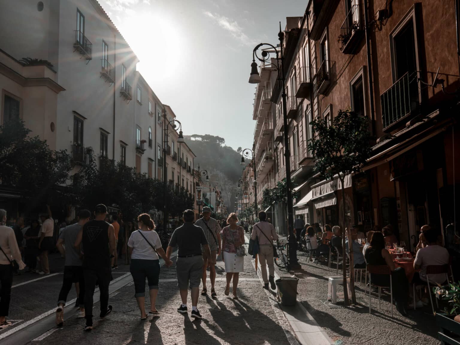 Eine Gasse mit vielen Menschen und bunten Häusern.