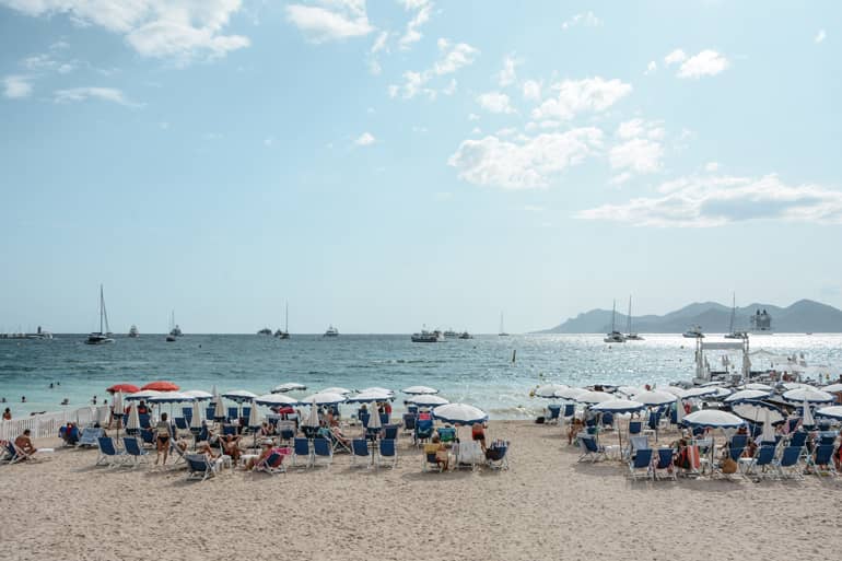 Ein Strand mit Liegestühlen und Sonnenschiermen.