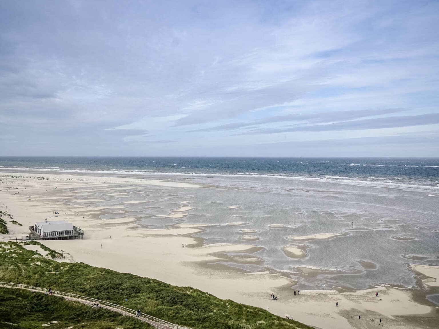 Blick auf einen niederländischen Strand und die Küste, im Hintergrund der Himmel