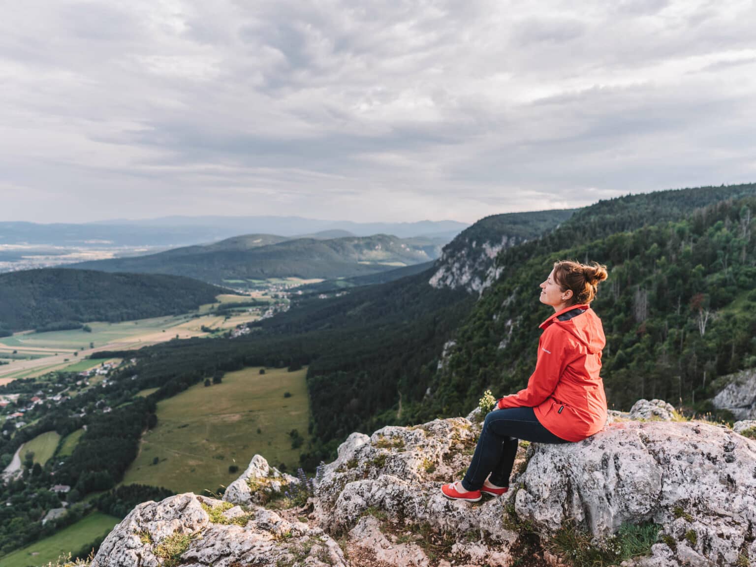 Bloggerin Melanie sitzt auf einem Felsenvorsprung im Naturpark Hohe Wand, der von Wien aus nur eine Stunde Autofahrt entfernt ist.