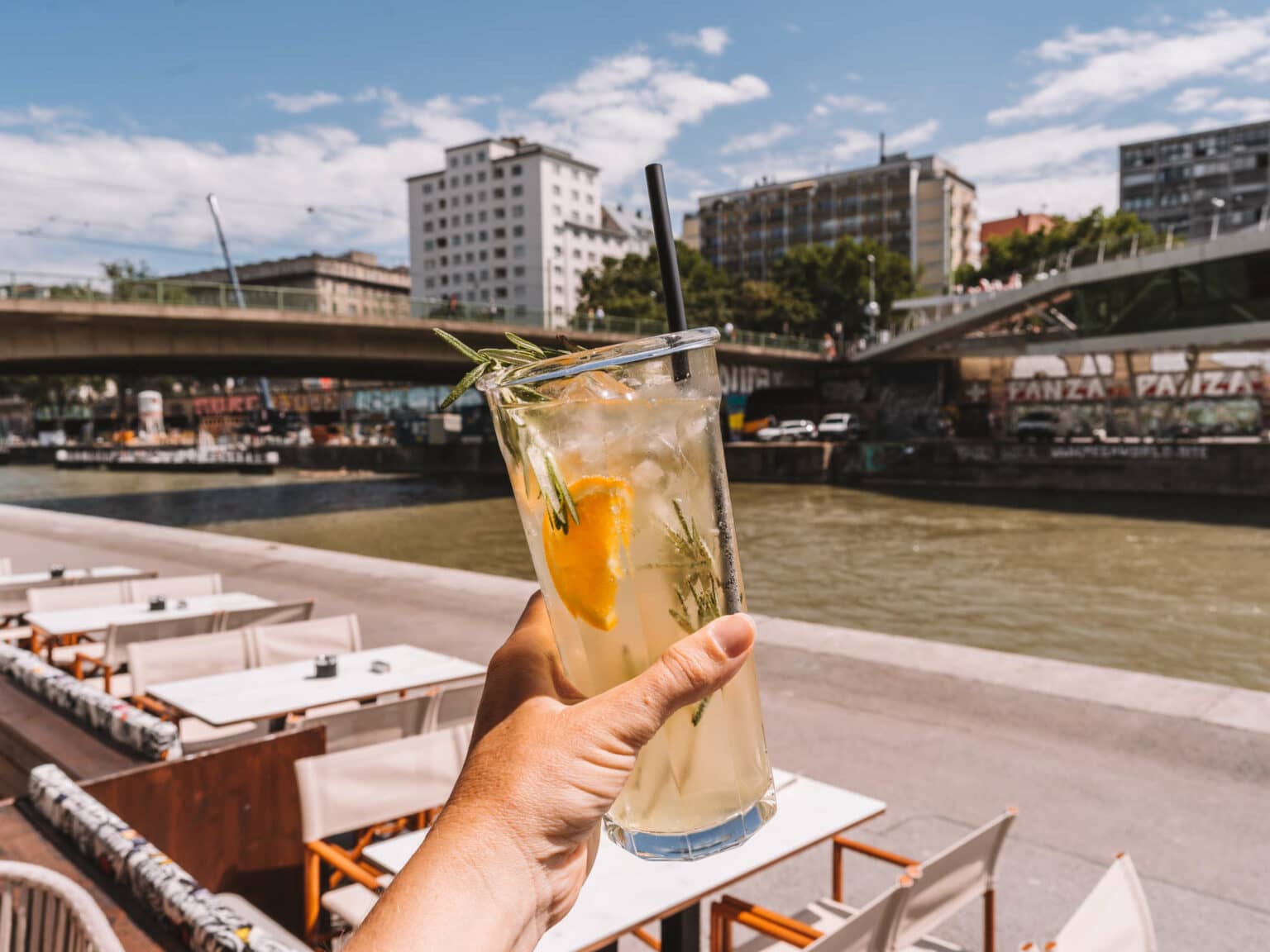 Mit einem Glas frischer Limonade in der Hand erholt sich Bloggerin Melanie in einem Café am Donaukanal von ihrer Tour durch Wien.