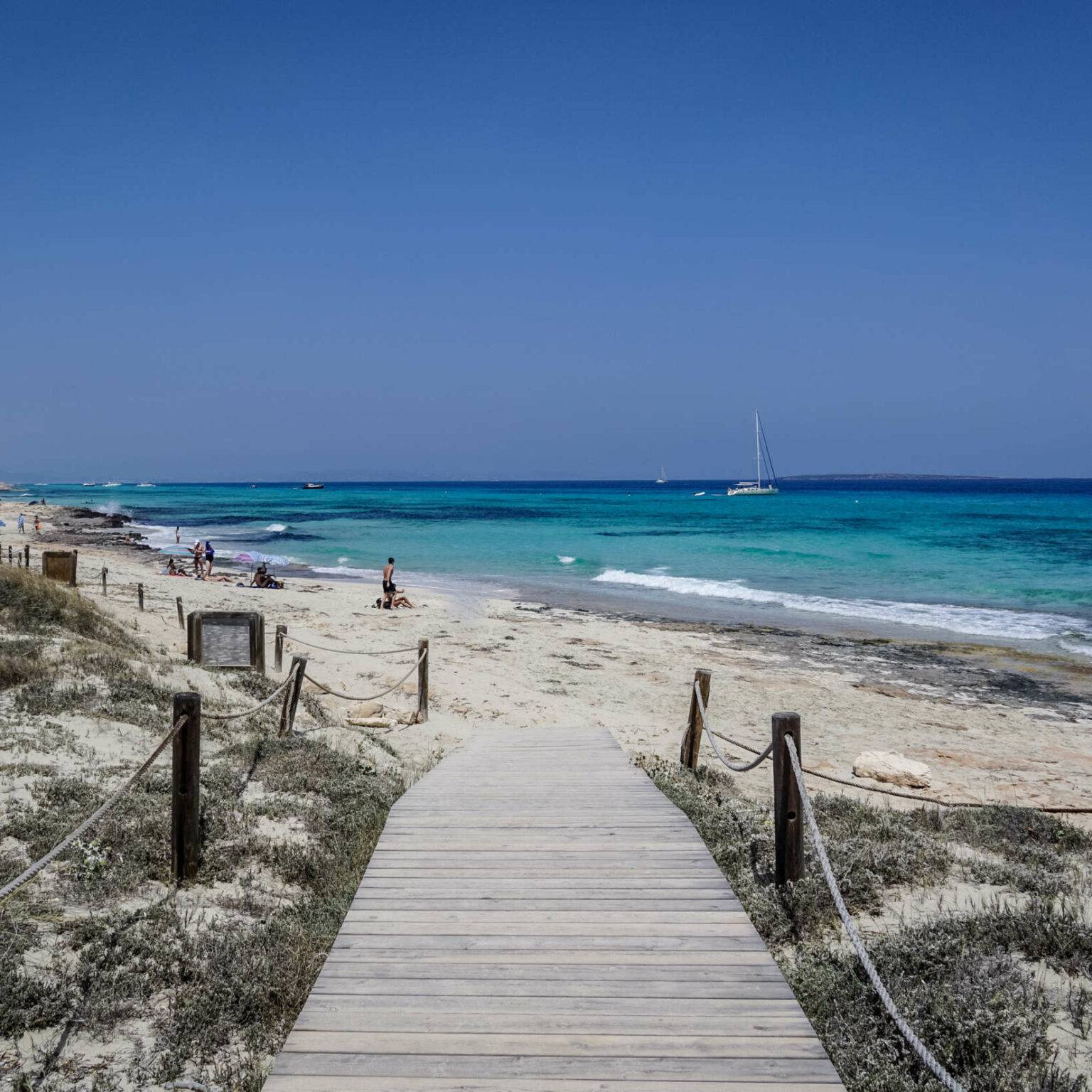 Ein Holzweg führt an einen unberührten Strand von Formentera.