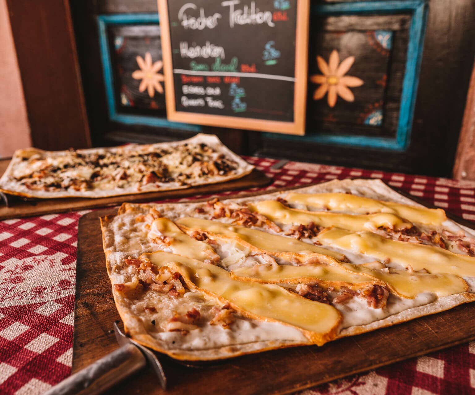 Schon längst kein Geheimtipp mehr: Flammkuchen mit saftigen Zwiebeln, herzhaften Speckwürfeln und würzigem Münsterkäse im Restaurant Le Baeckeoffe d'Alsace im La Petite France in Straßburg.