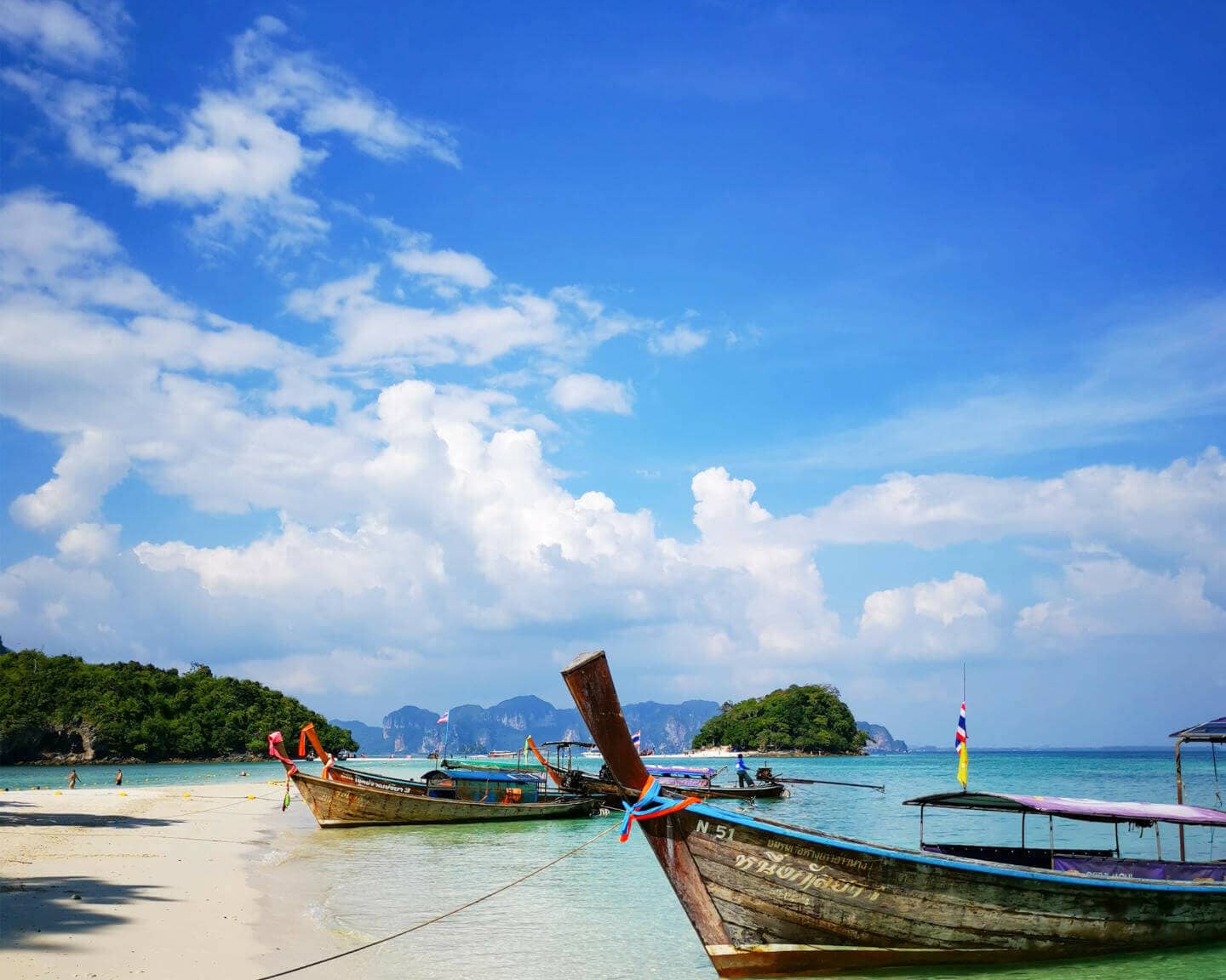 In Thailand kommt man am besten mit Longtailbooten auf die Inseln und genießt dabei die Aussicht auf des Meer.
