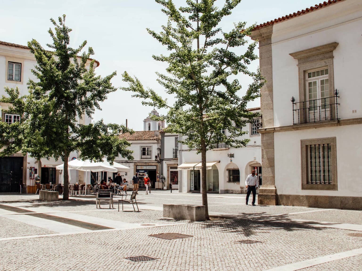 Ein schön gepflasterter Platz mit einem Außenbereichs eines Cafés in der Altstadt in Evora im Alentejo.