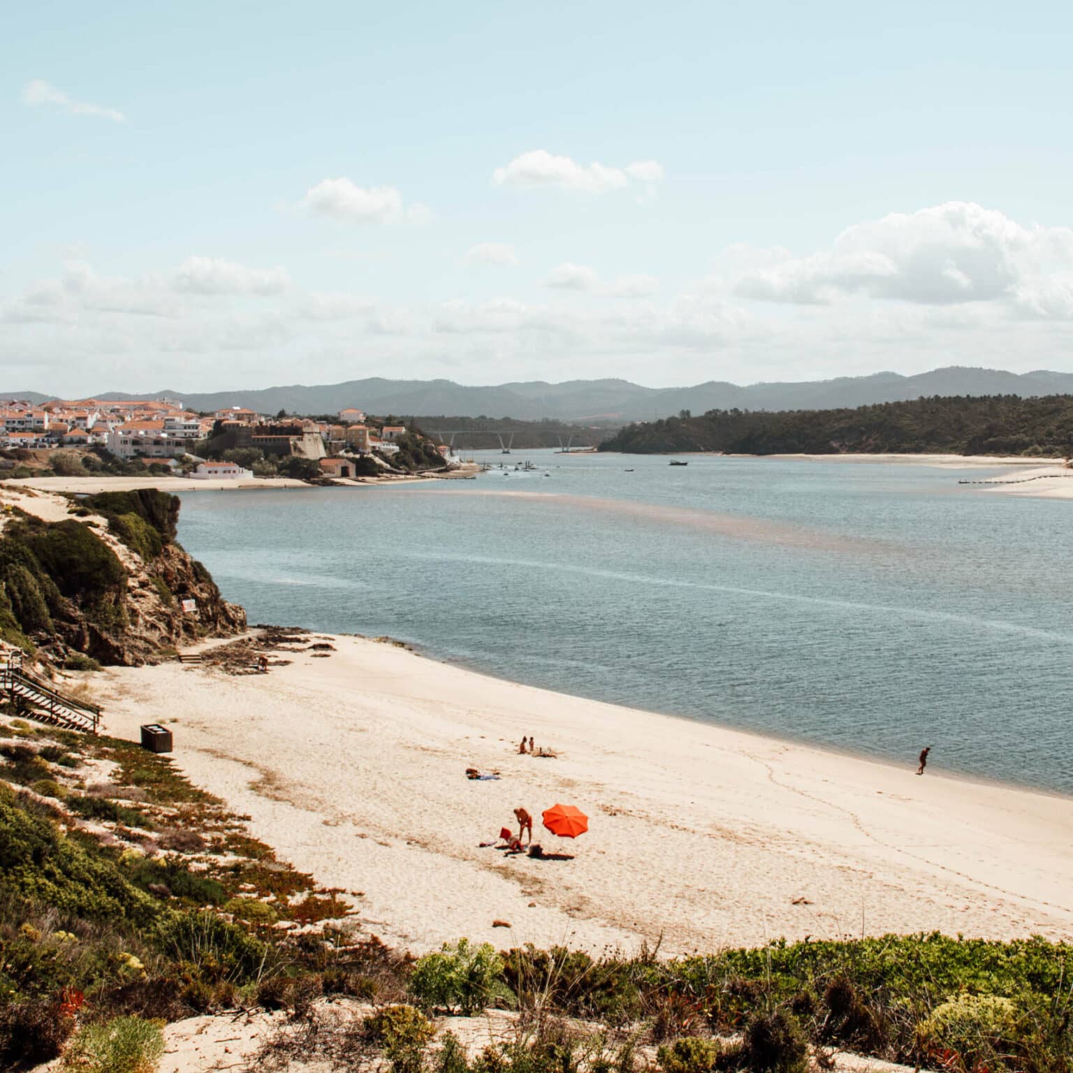 Ein roter Sonnenschirm als Farbklecks am traumhaften Strand