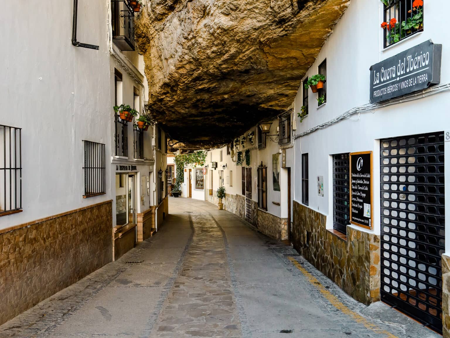 Ein spektakuläres Reiseziel ist das weiße Dorf Setenil de las Bodegas, bei dem Mitten in der Gasse ein Fels rausrakt.