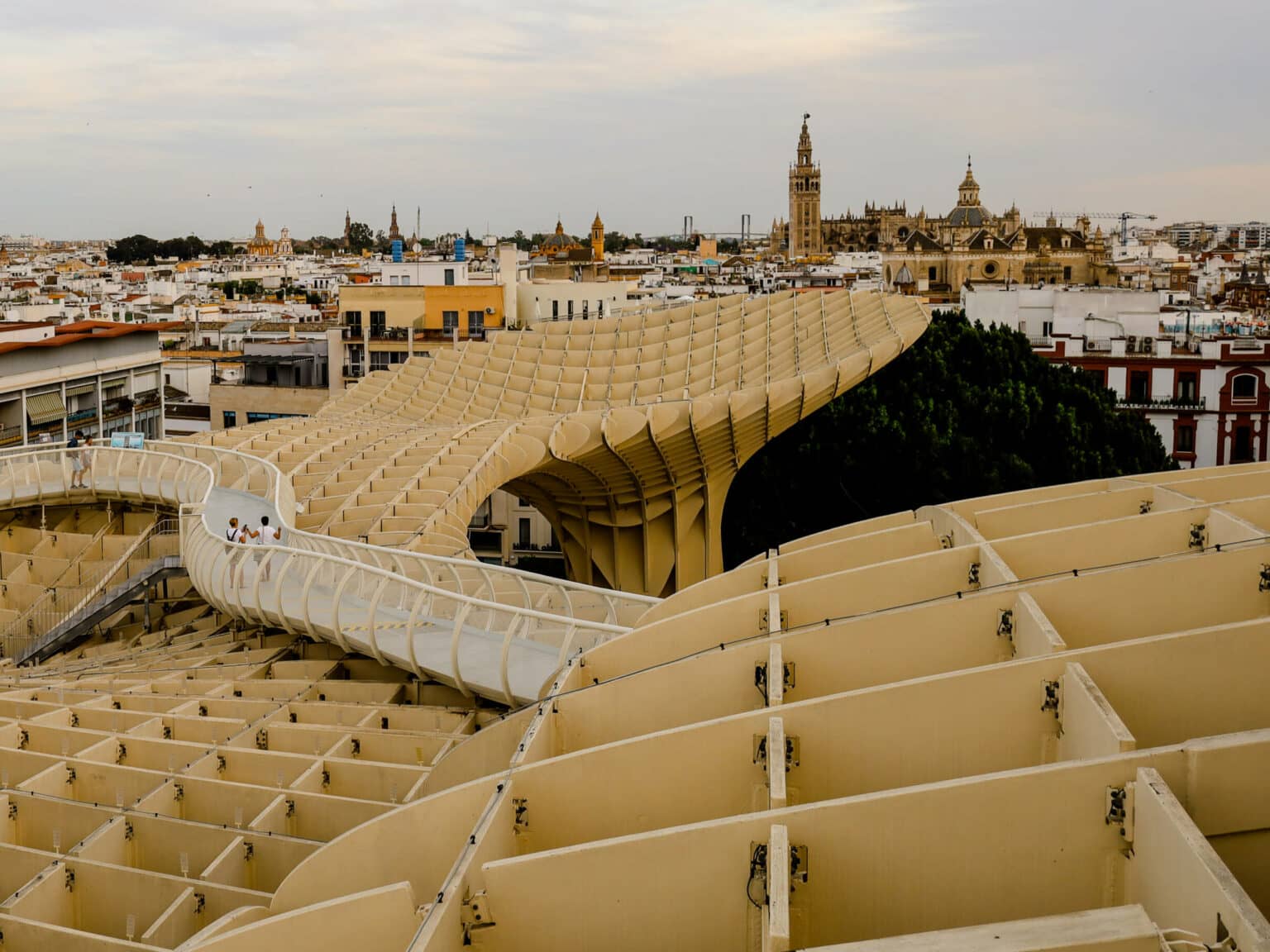 Eine Brücke führt über ein künstlerisches Gebilde, das Metropol, Parasol, über den Dächern von Sevilla hinweg. In Spanien gibt es viele wunderschöne Reiseziele und Geheimtipps wie diese.