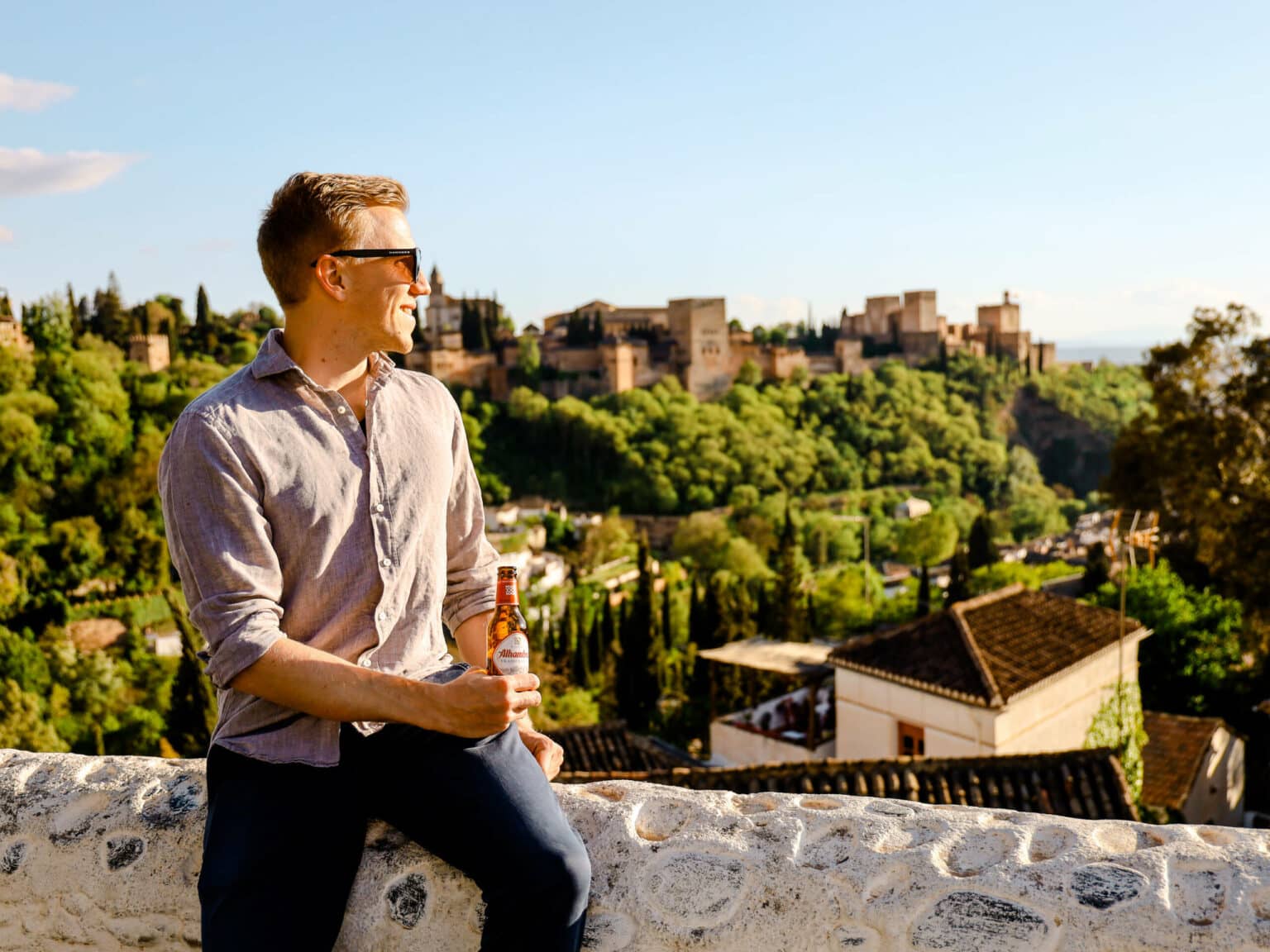 Auf der Mauer von Mirador de la Vereda de Enmedio die Sonnenstrahlen und die Aussicht über Alhambra genießen.