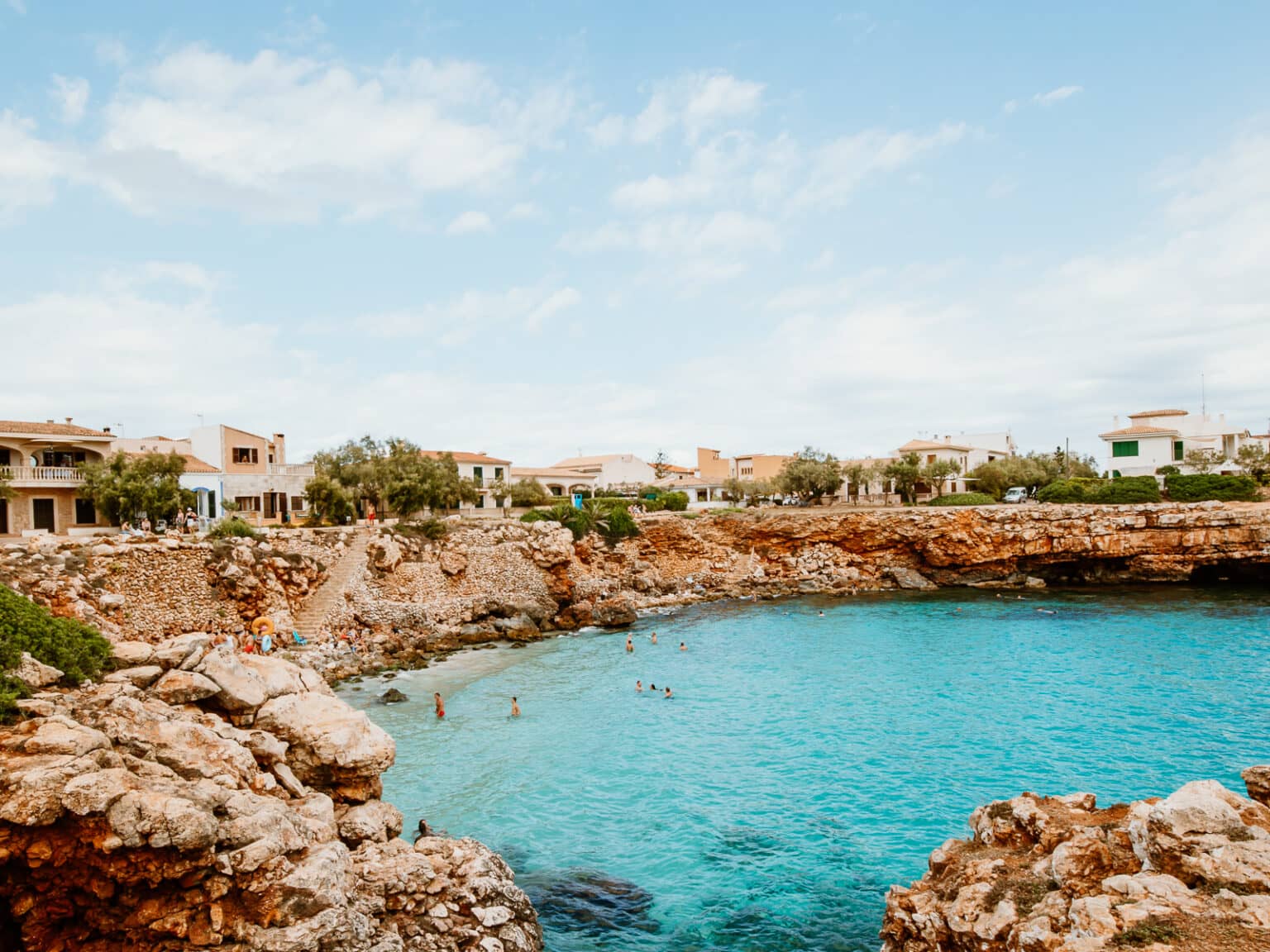 In der Bucht Cala Morlanda umfassen felsige Vorsprünge das türkisblaue Meer.