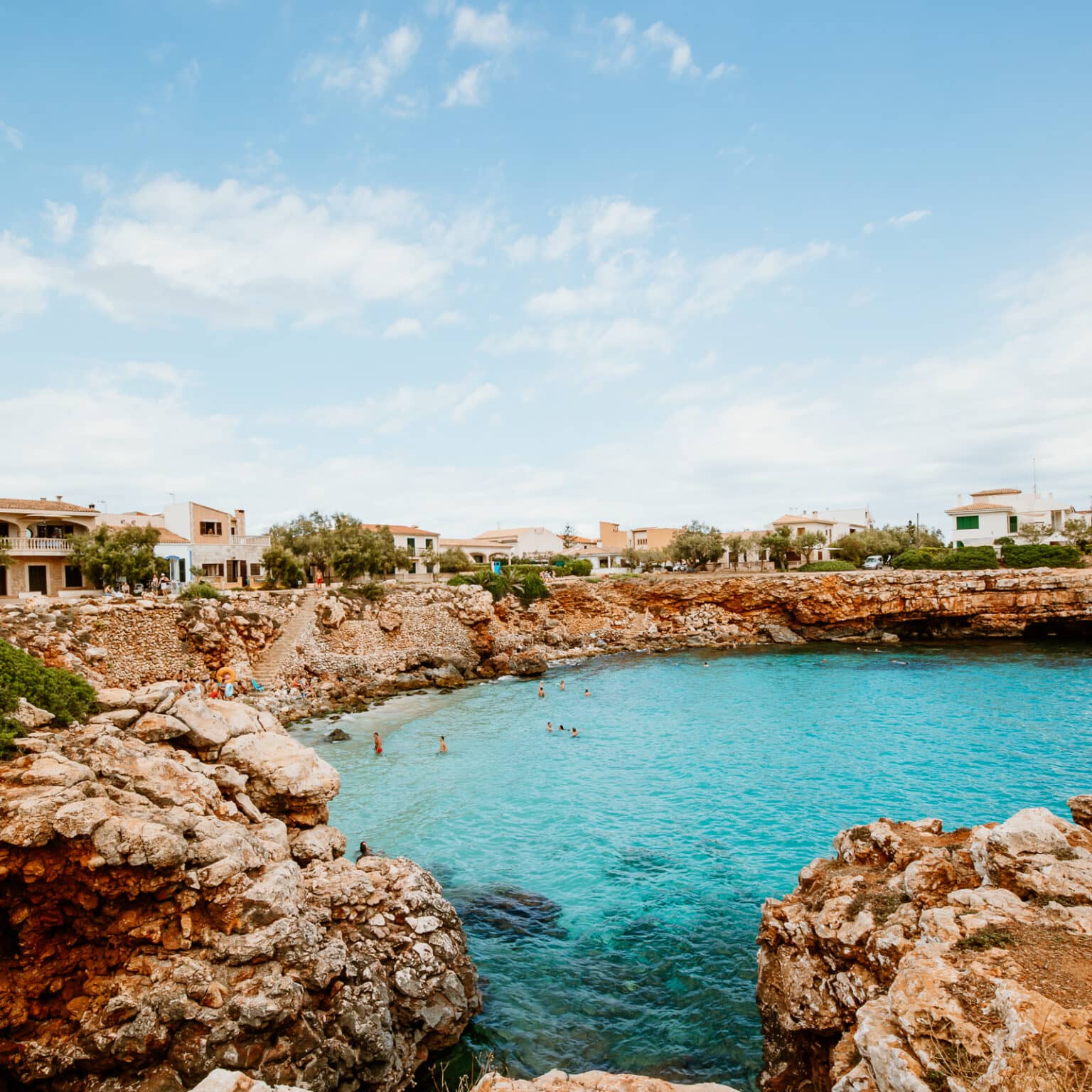 In der Bucht Cala Morlanda umfassen felsige Vorsprünge das türkisblaue Meer.