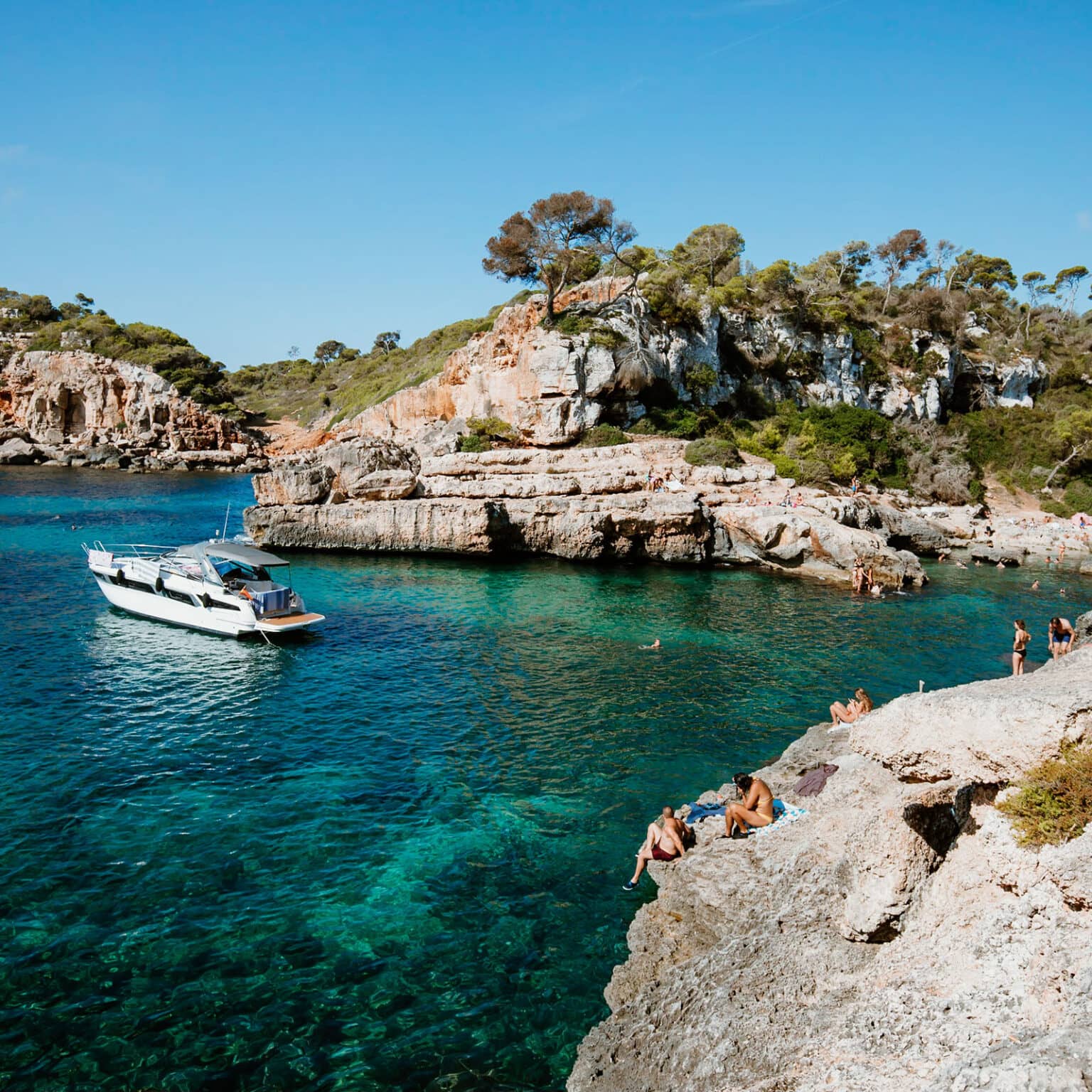 Die felsigen Steinausbuchtungen in der Bucht Cala s’Almunia führen direkt ins tiefblaue Meer.