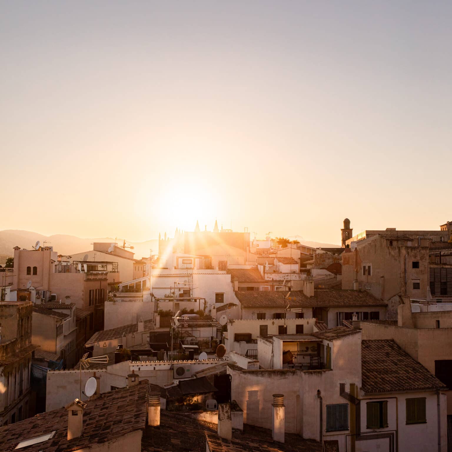 Ein Sonnenuntergang über den Dächern des weißen mallorquinische Dorfs Palma.