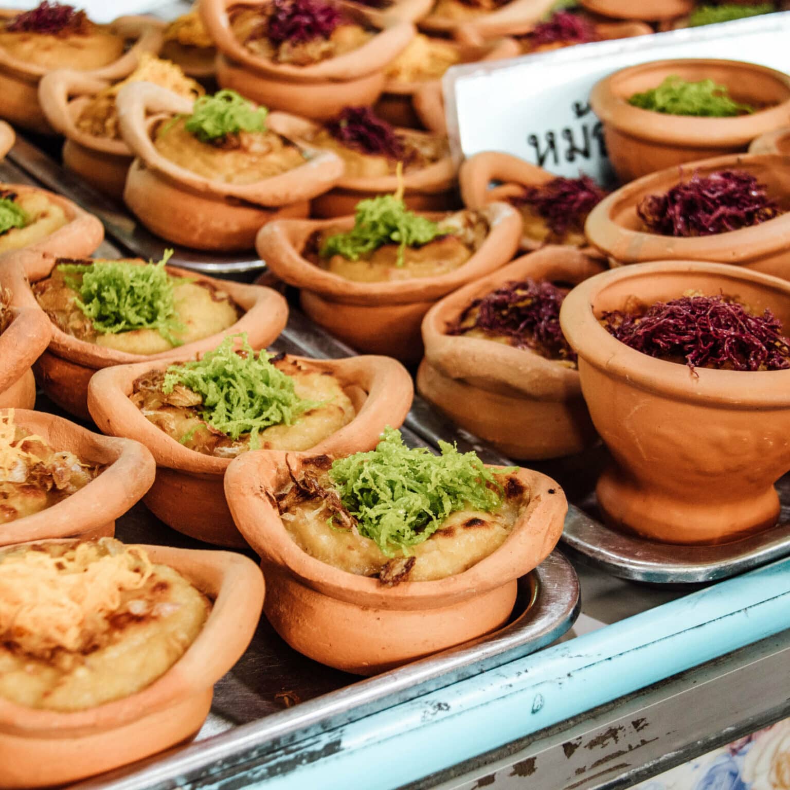 Bangkok Essenstipps: thailändische Desserts in kleinen Tonschalen serviert sind richtige Delikatessen.
