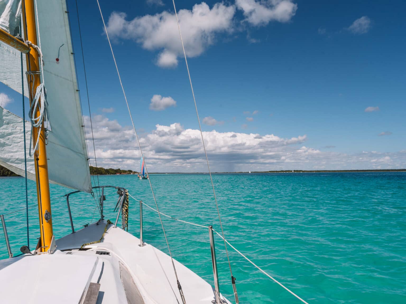 Ein Segelschiff auf dem türkisblauen Meer in der Laguna Bacalar.