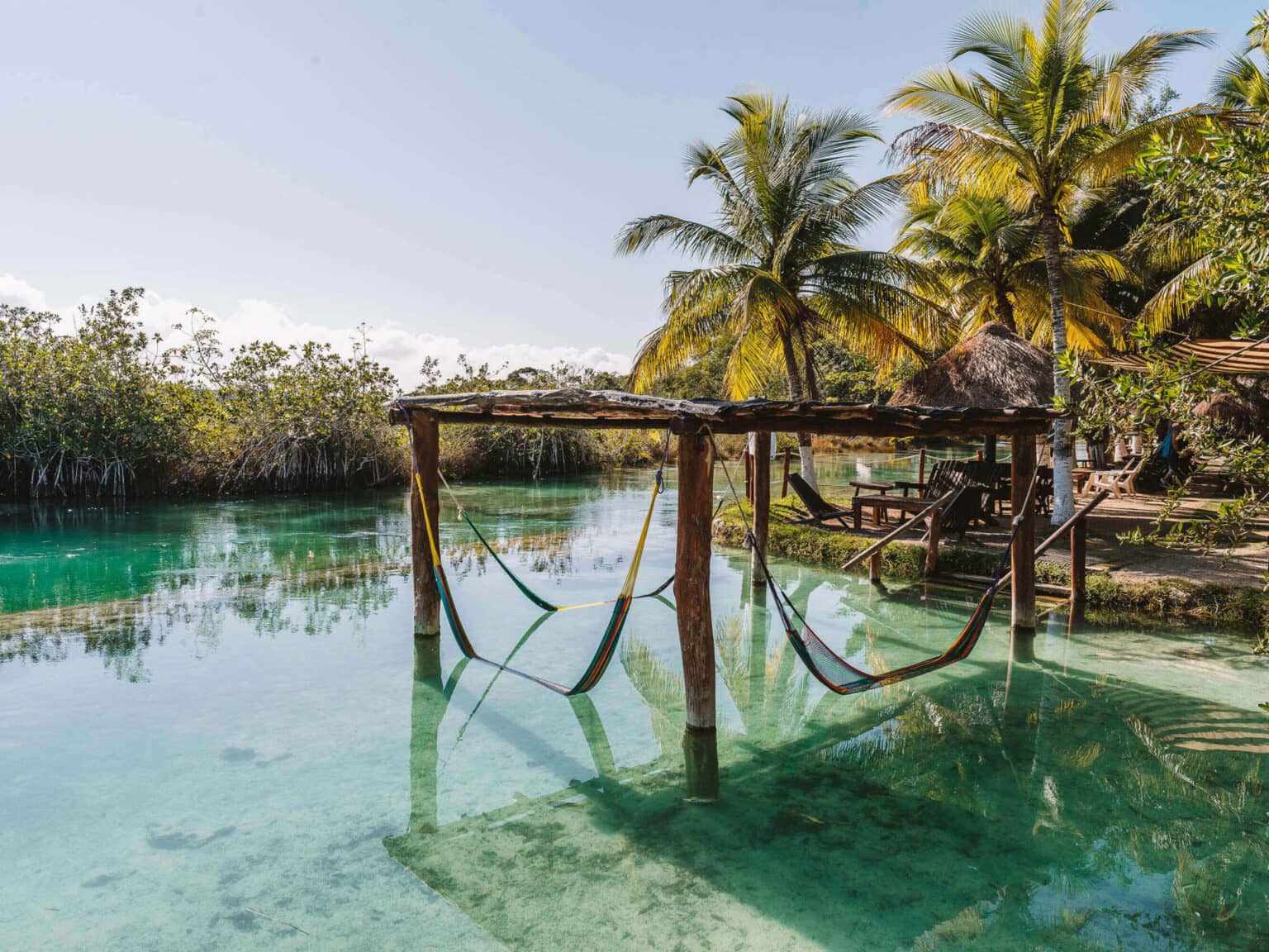 Eine Holzkonstellation steht mit Hängematten im Wasser am Kanal von Los Rapidos auf Yucatan.