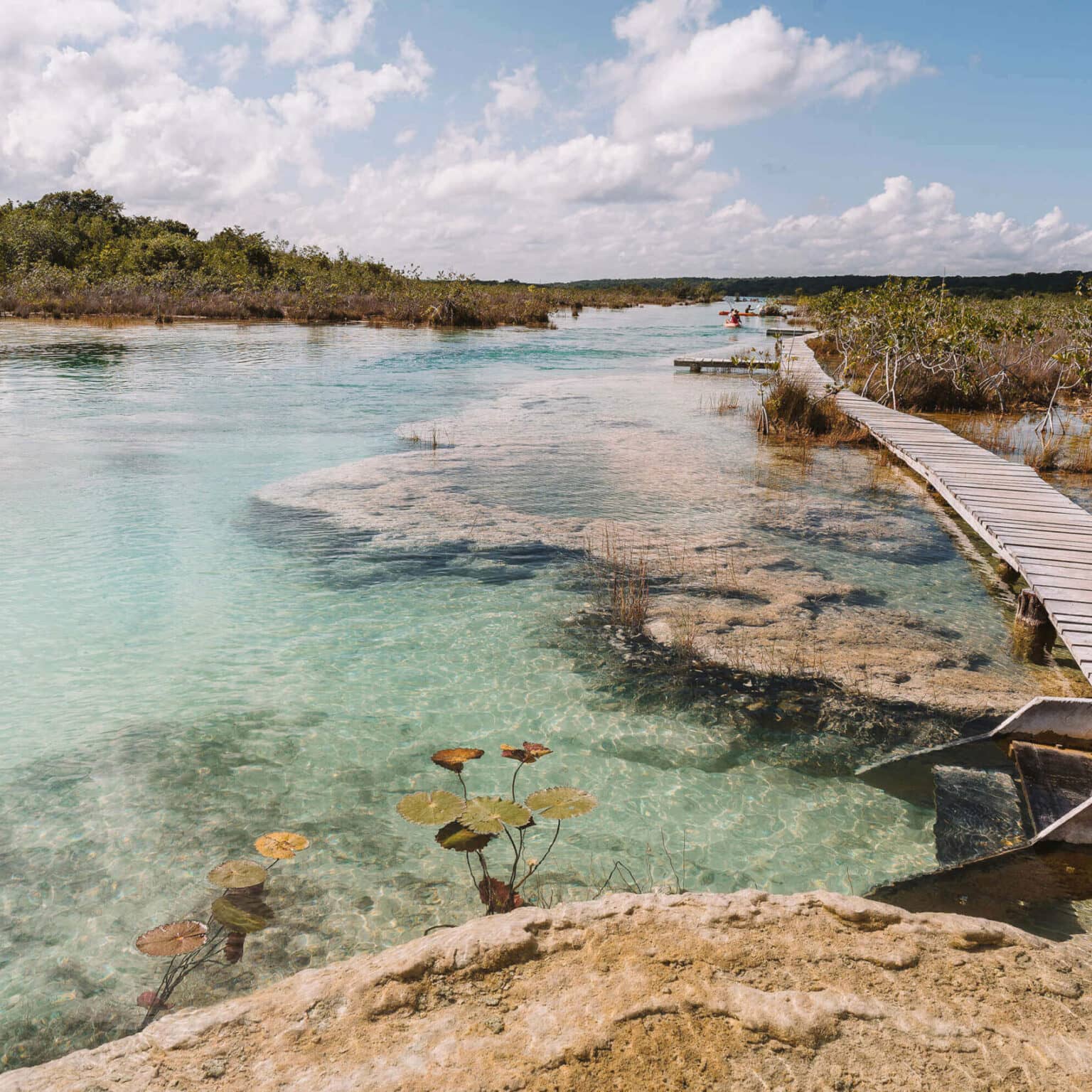 Ein Holzsteg auf Yucatan führt über das türkisfarbene Wasser des Strömungskanals Los Rapidos.