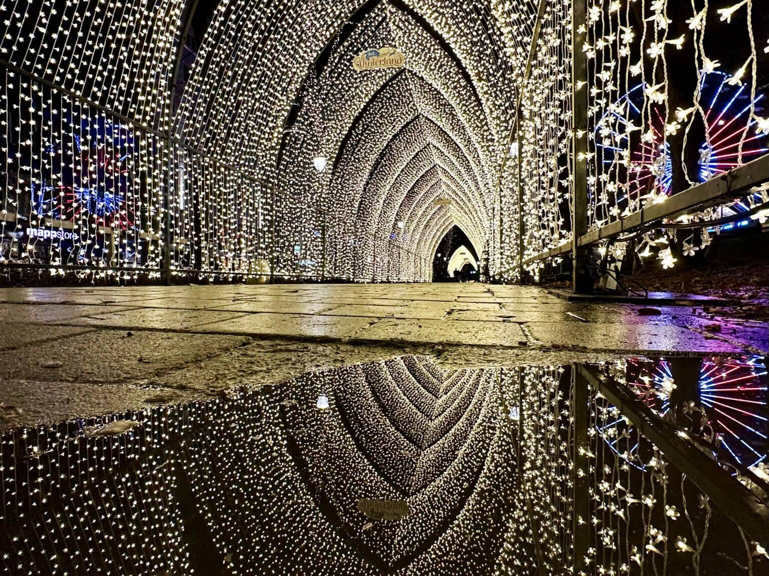 Der Lichtertunnel aus vielen weiß leuchtenden Lichterkettenauf dem Weihnachtsmarkt in Oslo bei Nacht.