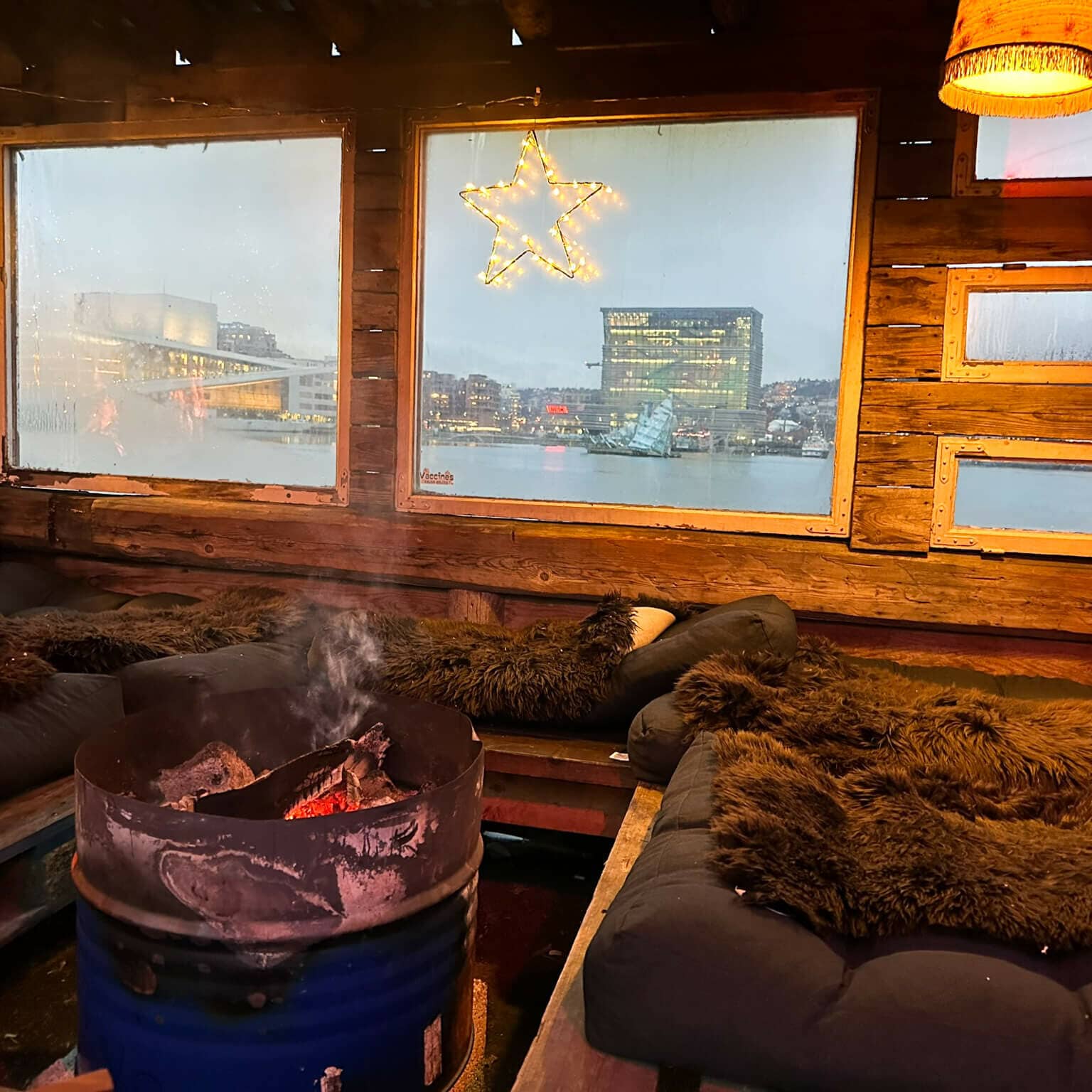 Eine Sitzecke mit Fellen und einem Feuer auf dem Weihnachtsmarkt auf dem SALT-Gelände in Oslo