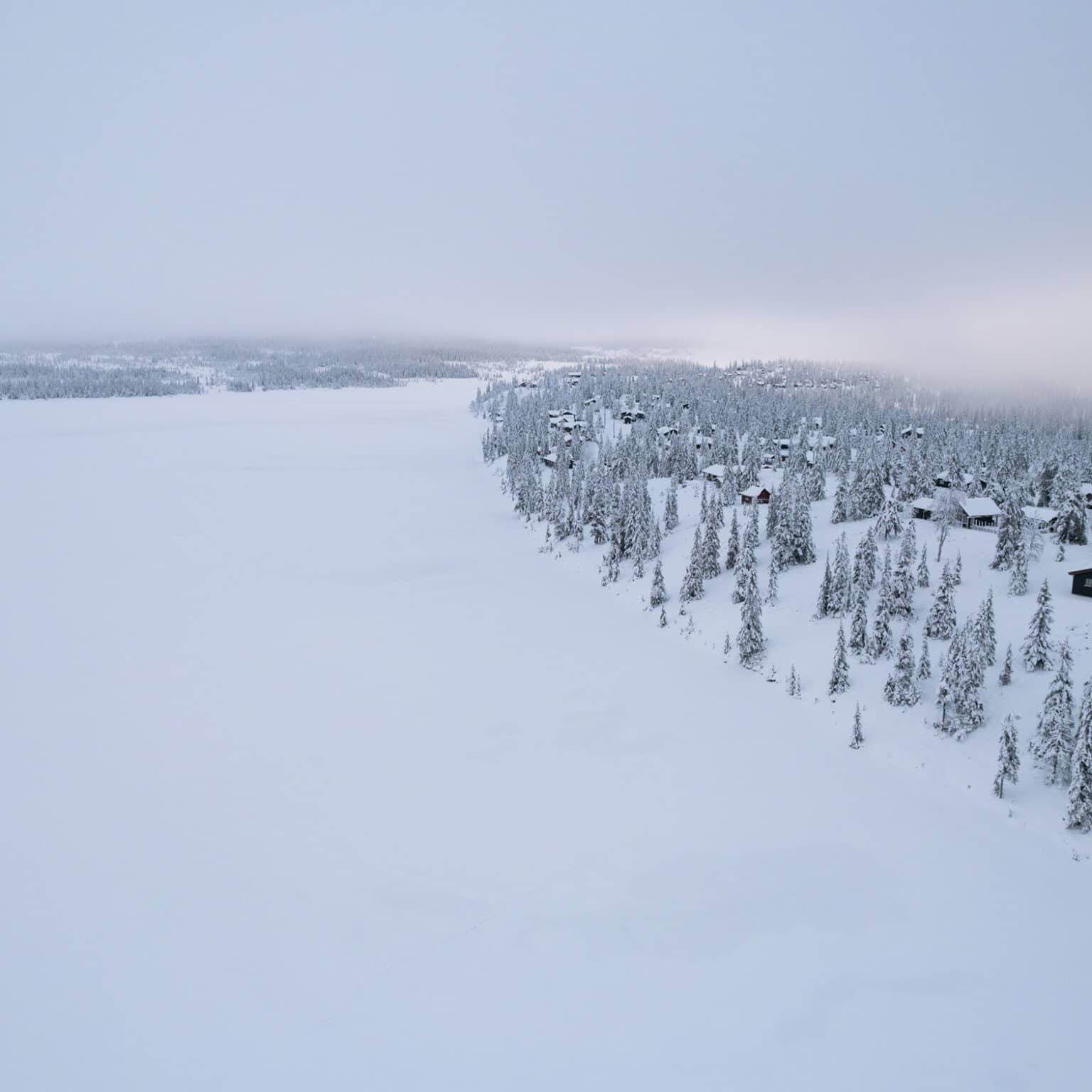 Ein zugefrorener und verschneiter See in der Winterlandschaft in Sjusjøen