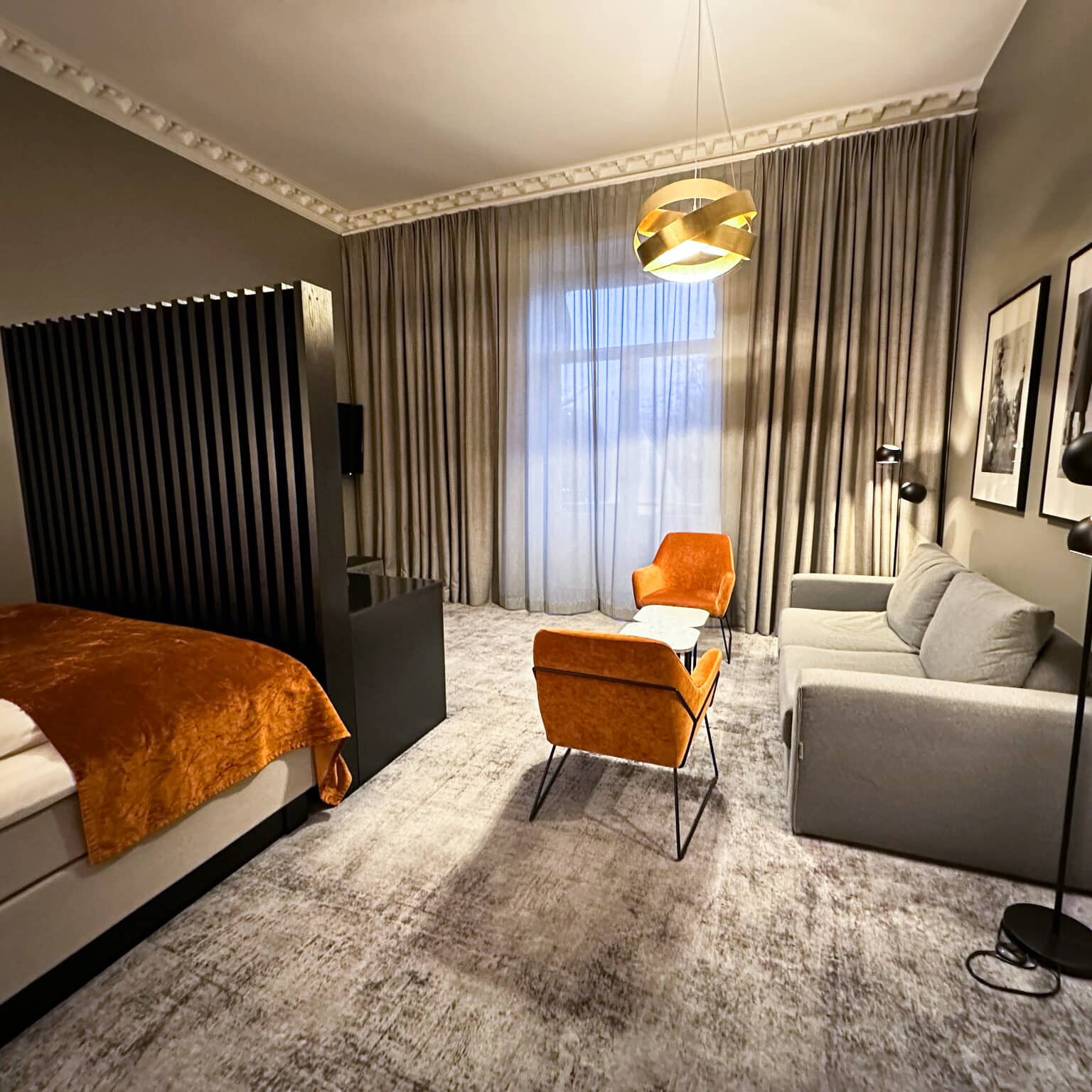 Ein Zimmer im Karl Johan Hotel in Oslo mit grauen und orangenen Möbeln.