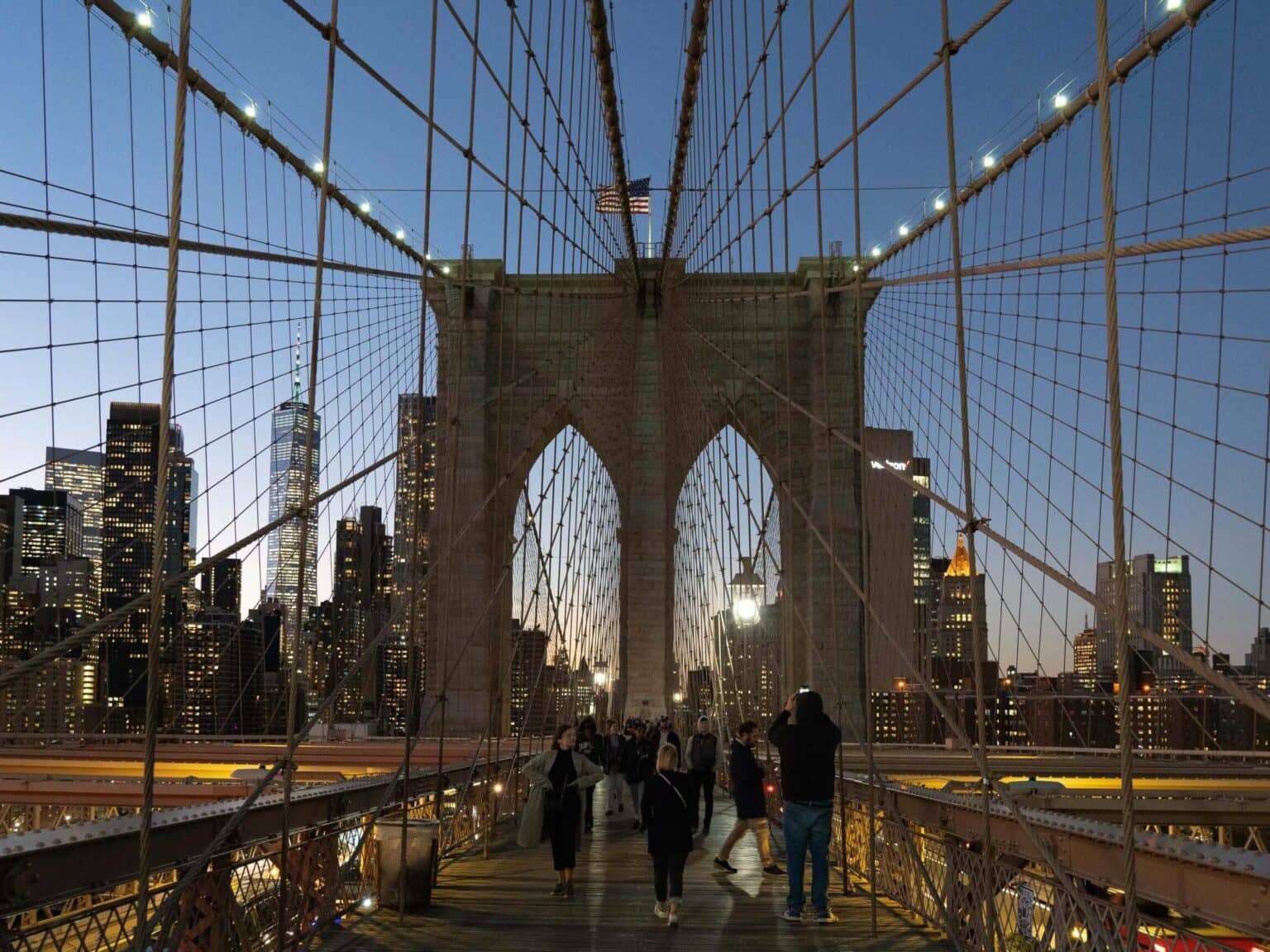 Die Brooklyn Bridge bei Nacht mit der beleuchteten Skyline im Hintergrund.