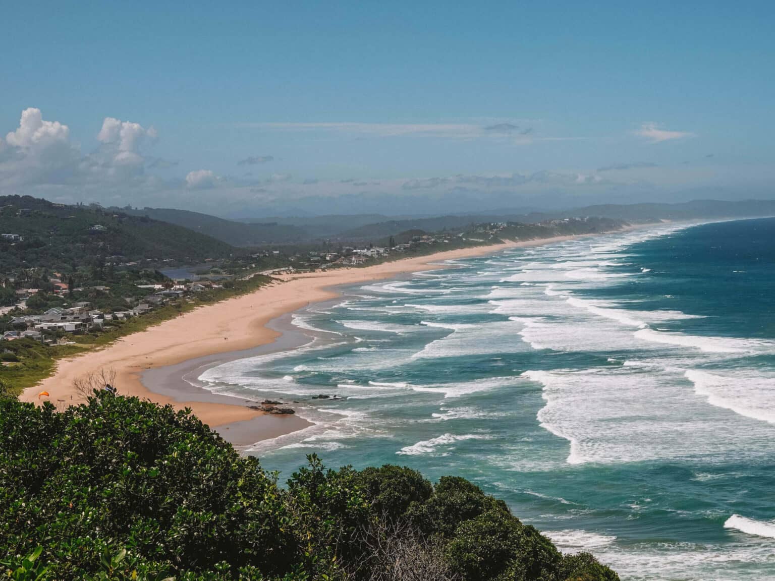 Blick vom Dolphin Point auf den Strand und das türkisblaue Meer in Wilderness in Südafrika.