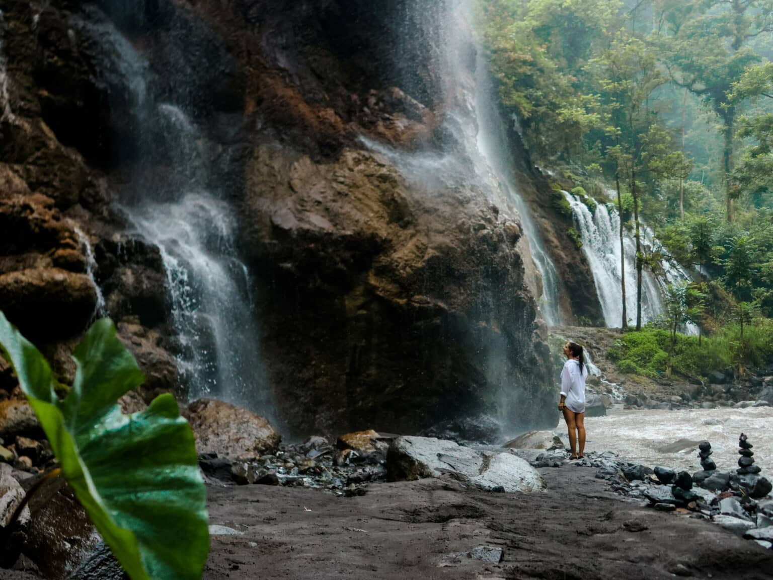Bloggerin Nina steht am Fuße eines Wasserfalls in Java.