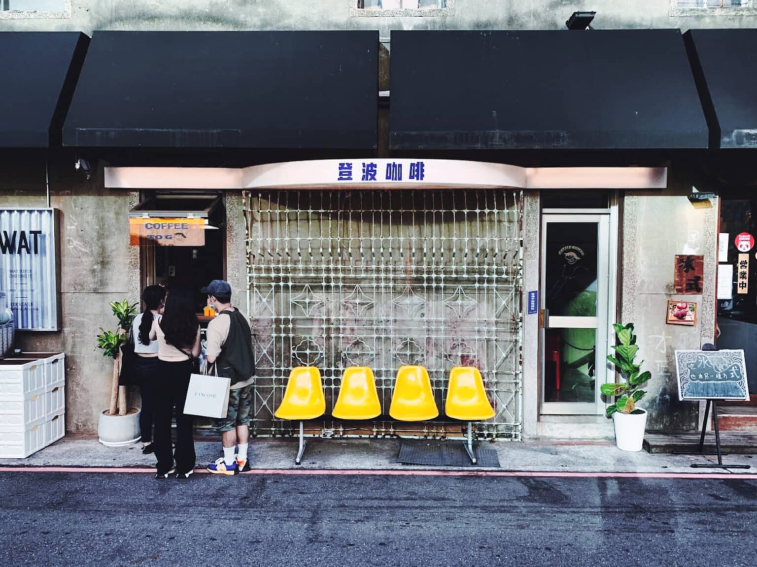 Das kleine Dumbo Café in taipeh mit gelben Stüheln vor dem Laden.