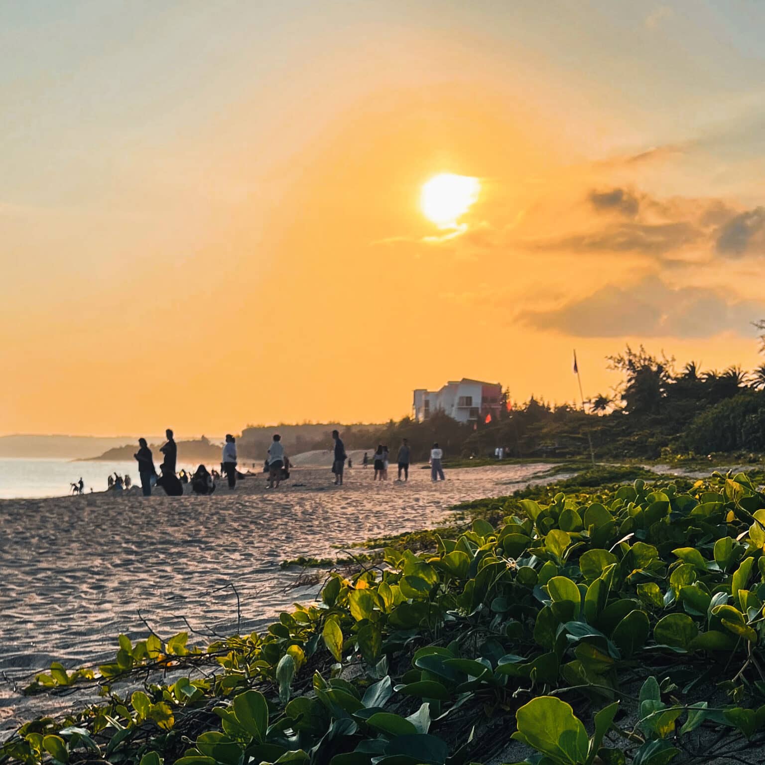Menschen schauen sich den Sonnenuntergag am Strand des Dawan Beach in Taiwan an.