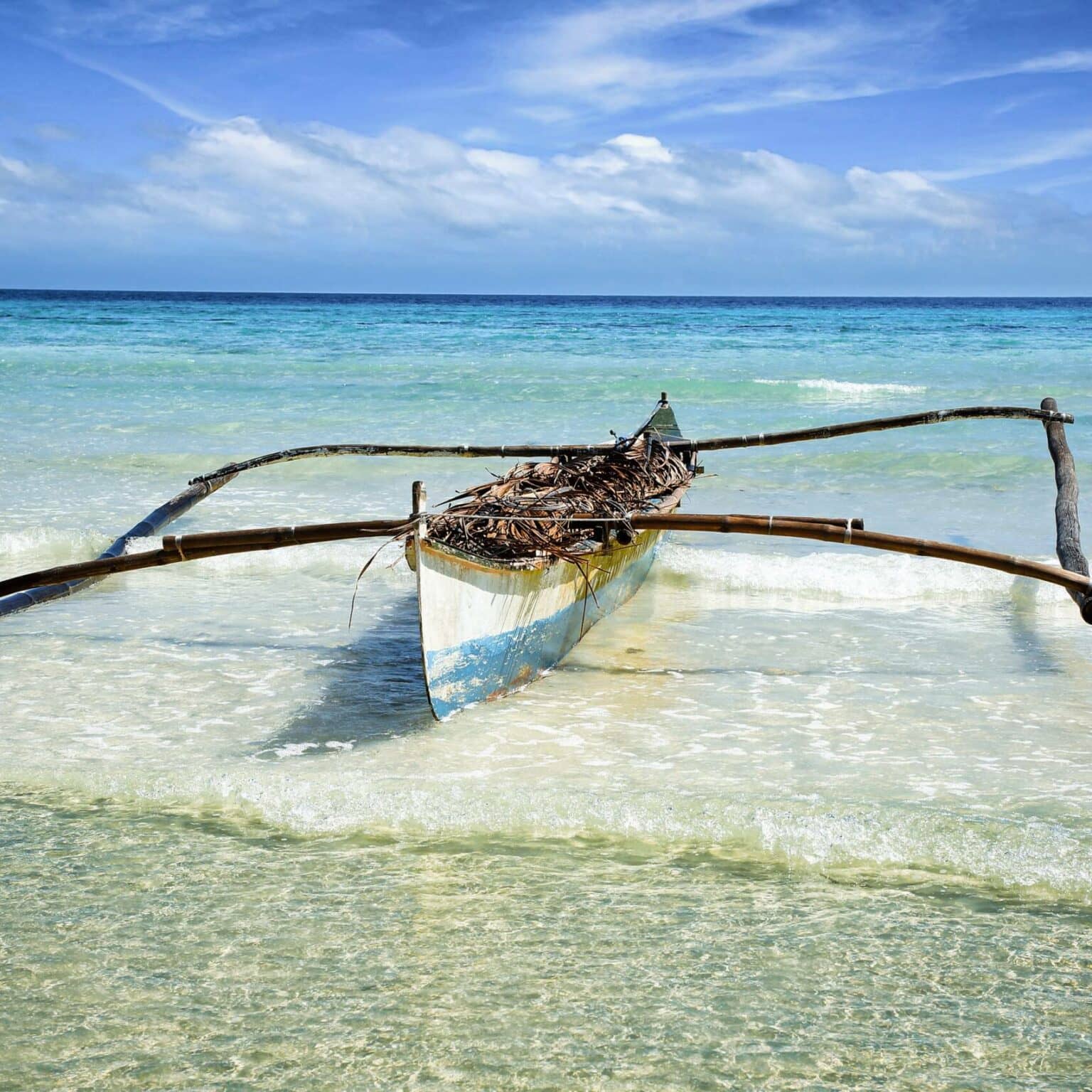 Ein altes Kanu aus Holz liegt an der Küste am Meer von Anda auf Philippinens Insel Bohol.