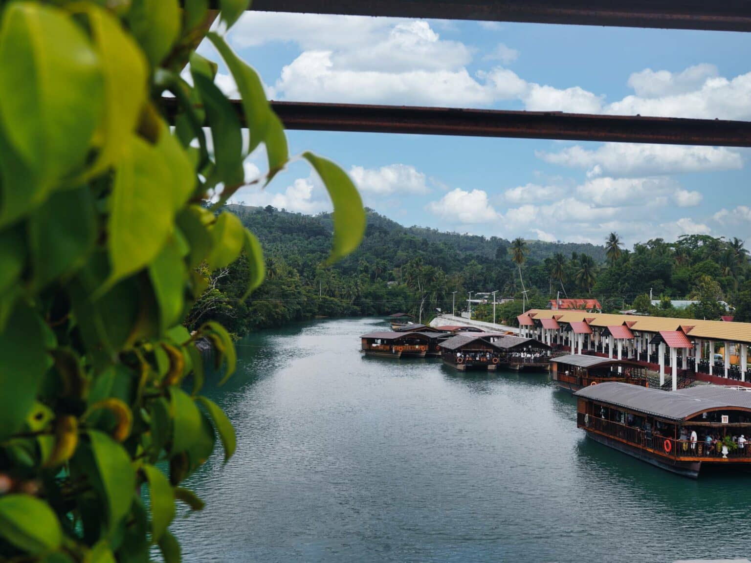 Holzboote reihen sich auf dem Loboc River auf Bohol entlang dem Ufer.