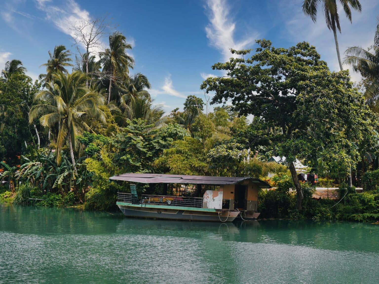 Ein kleines Holzboot steht am Ufer des Flusses Loboc River auf Bohol.