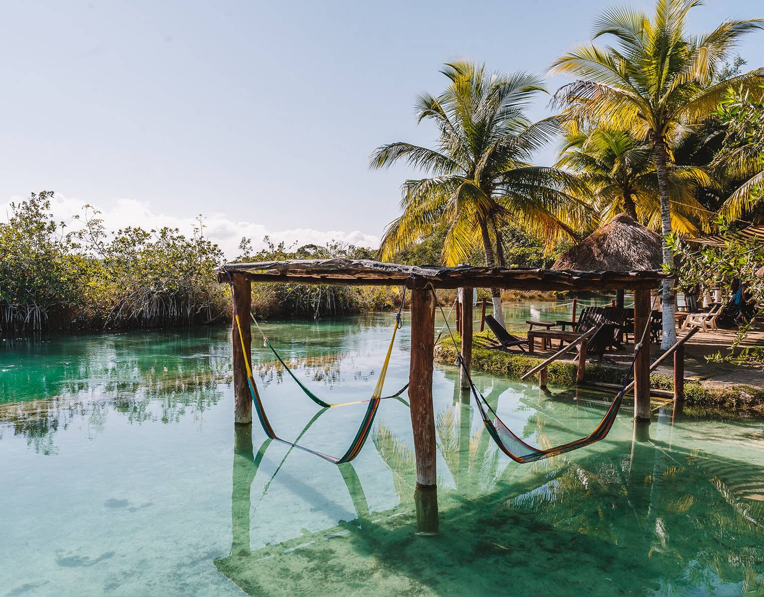 Eine Holzkonstellation steht mit Hängematten im Wasser am Kanal von Los Rapidos auf Yucatan.