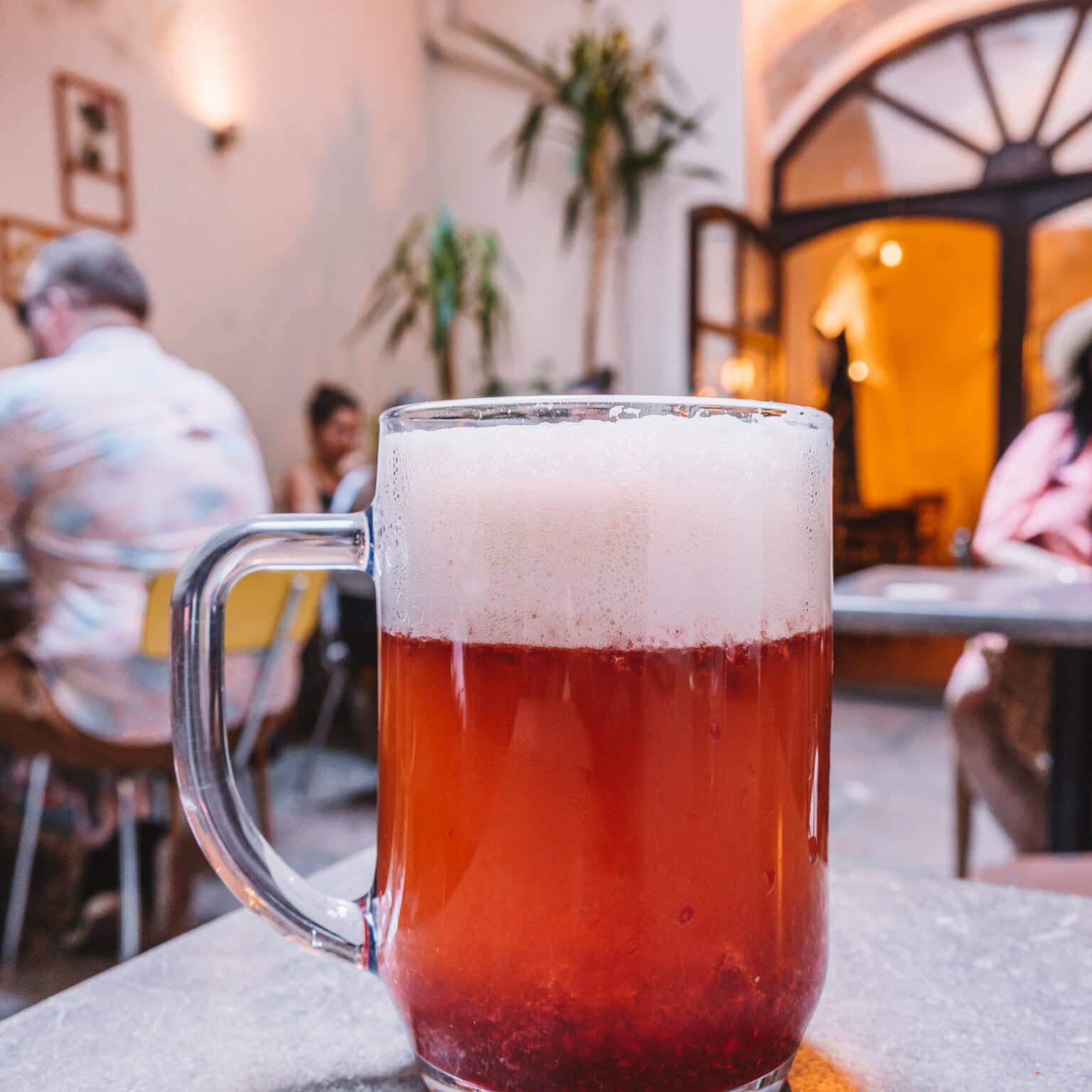 Ein Glas Bier mit Himbeer-Püree auf einem Tisch im ROESEL Bistro in Prag.