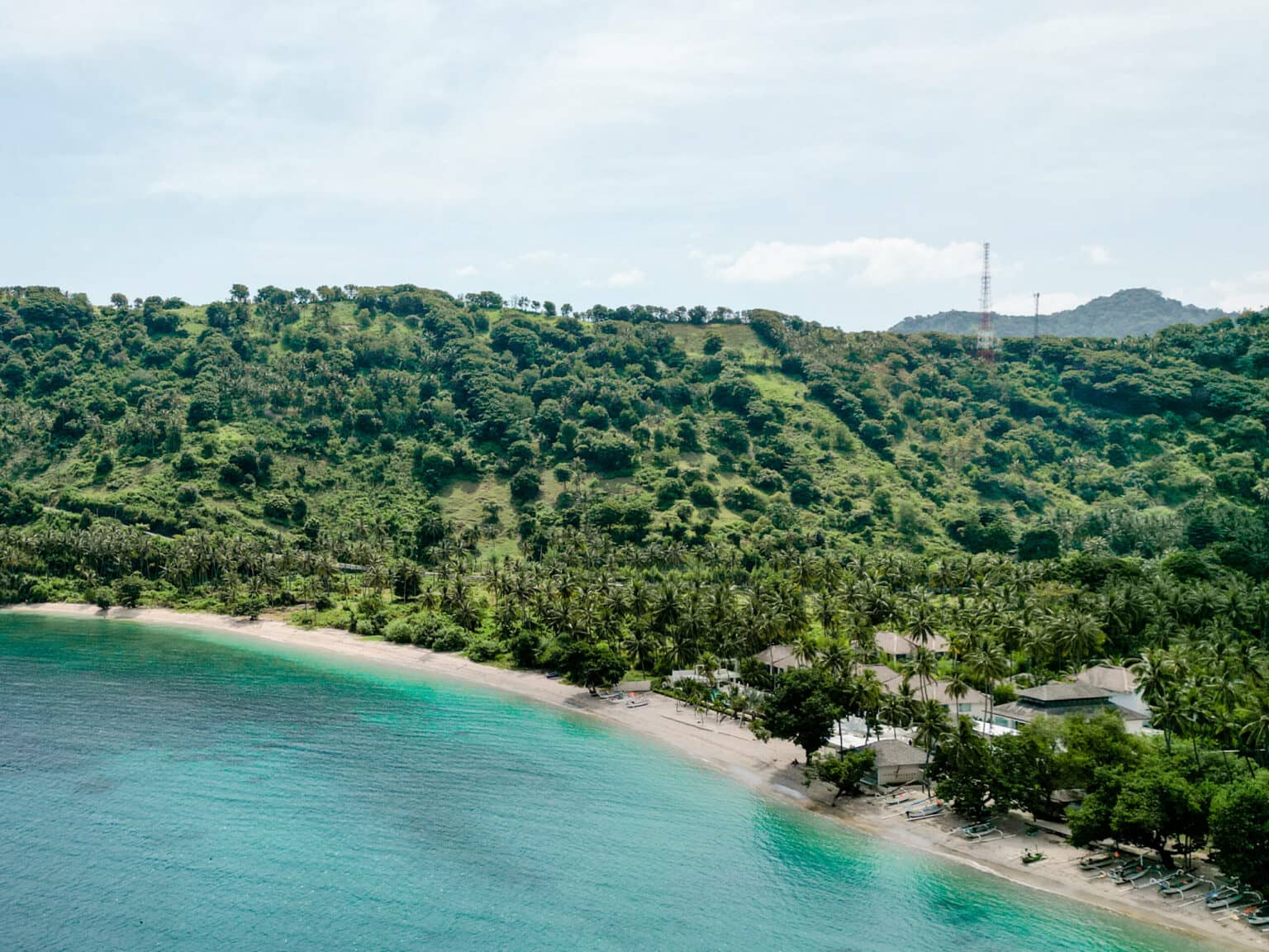 Das türkisblaue Meer am Nipah Beach und die grüne Hügellandschaft dahinter sind ein Insider Tipp auf Lombok.